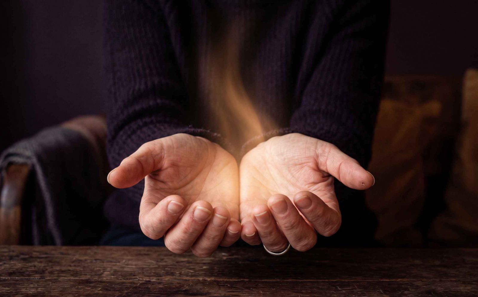 Mãos abertas com luz dourada fluindo entre elas simbolizando a percepção intuitiva e a escuta interior